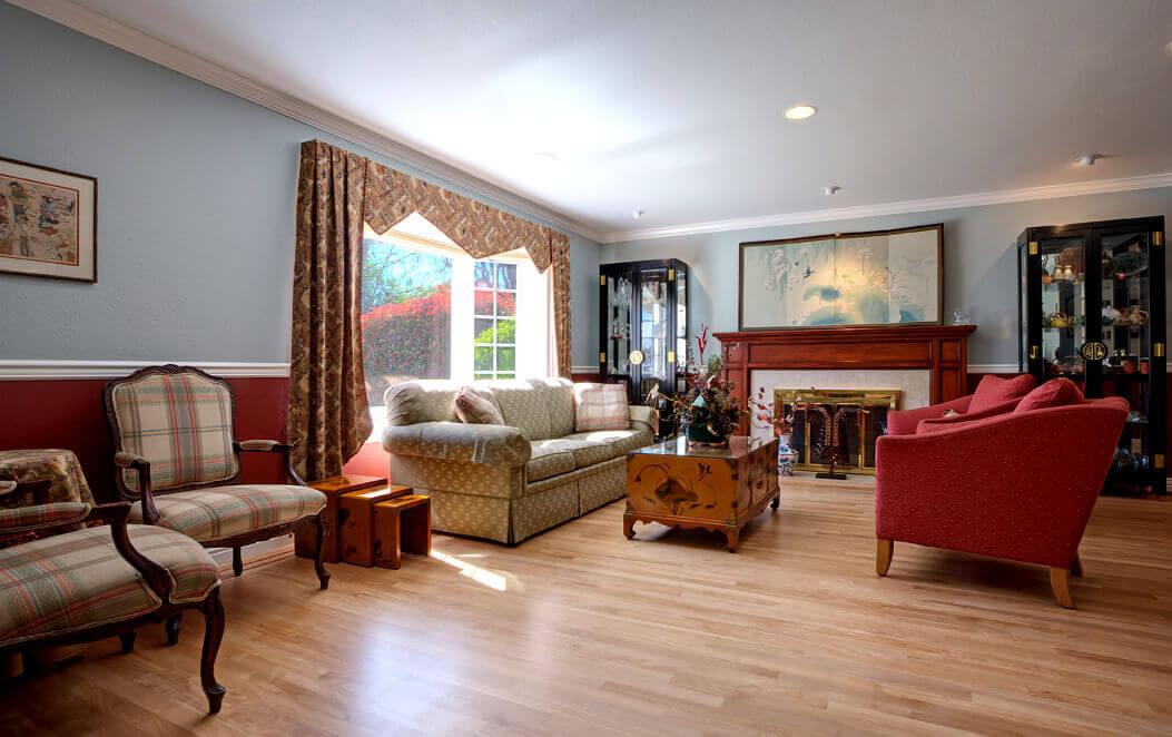 Saratoga living room with updated lighting, hardwood floor and custom cherry inlay border with fireplace mantle stained to match.